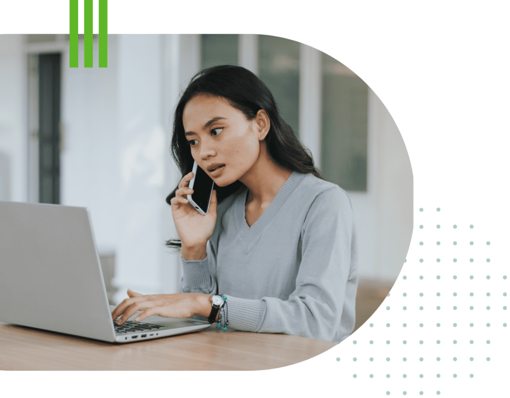 Photo of woman on telephone typing on computer